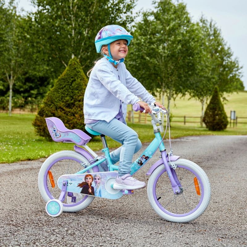 Child riding Disney Frozen bicycle in the park UK